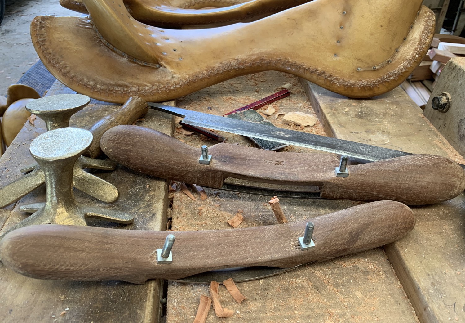 Saddle tree workshop bench with parts, two spoke shaves and a drawknife