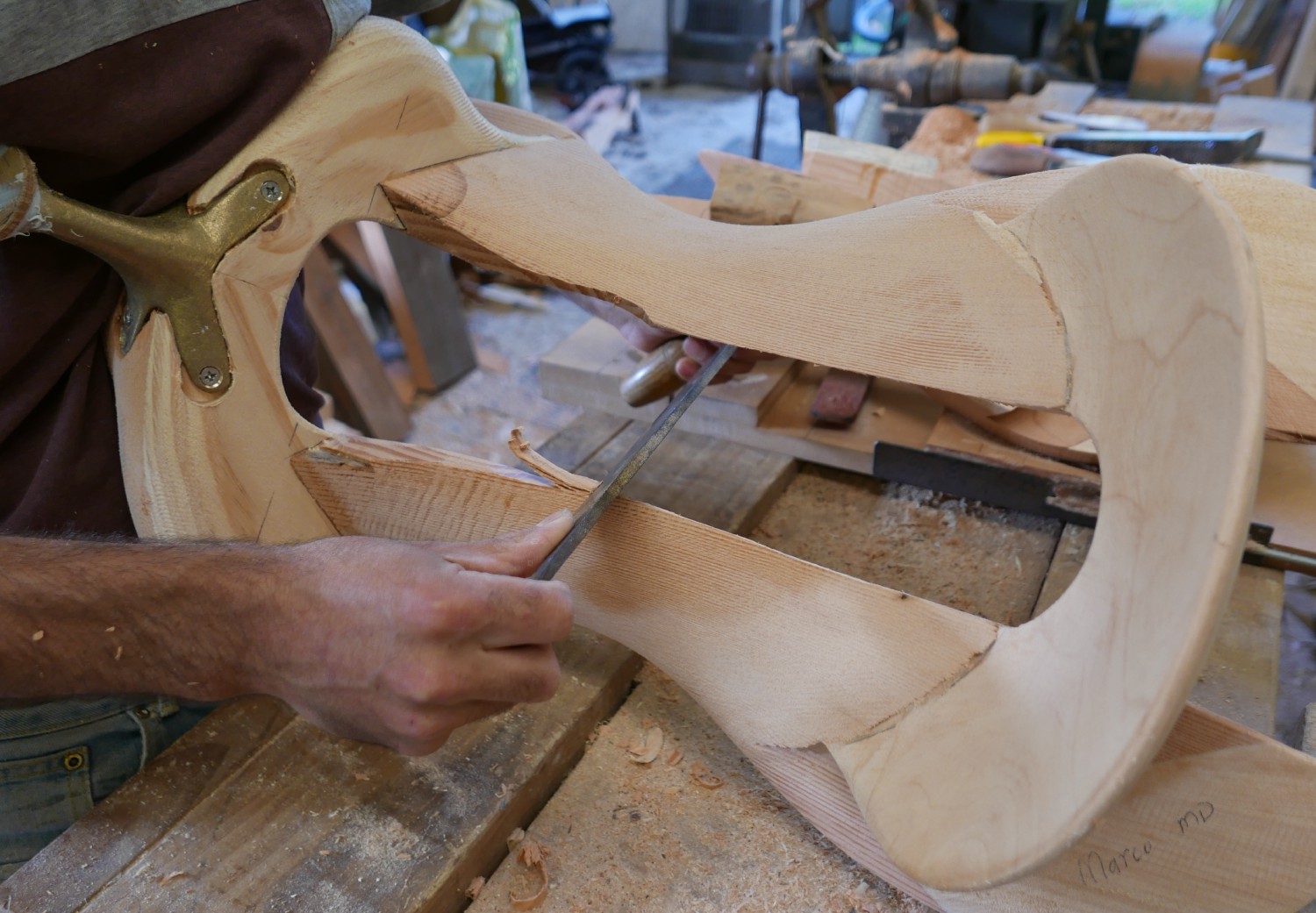 In progress wooden saddle tree being worked on with drawknife